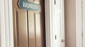 A door with a sign reading "RASPBERRY" and a white door next to it. - Great Water Inn (Bayfield)