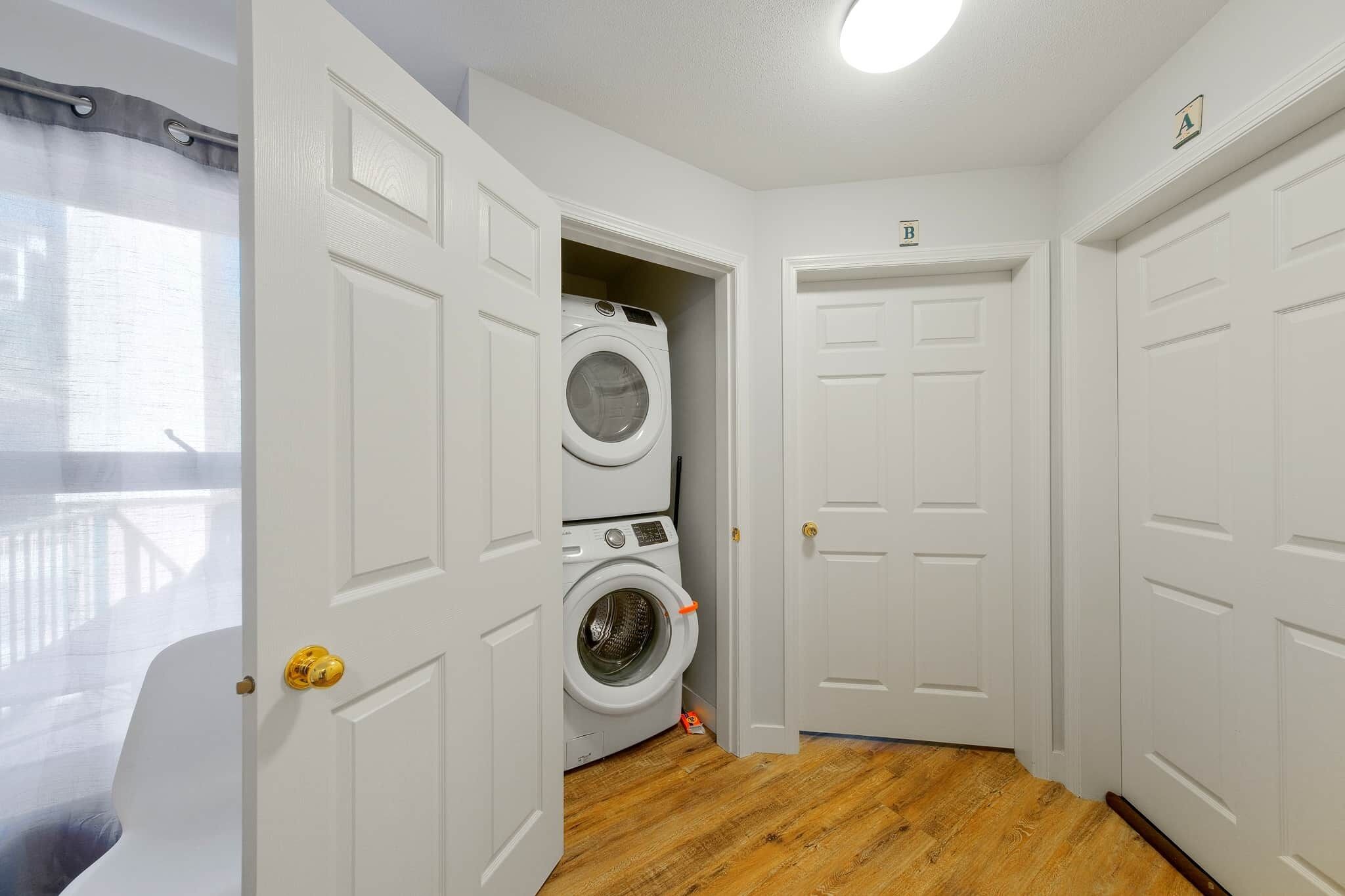 A laundry room with a washing machine, a dryer, and a door marked with an 'A' and 'B'.