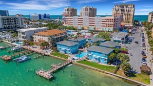 A coastal town with a marina, blue buildings, and a view of the ocean.