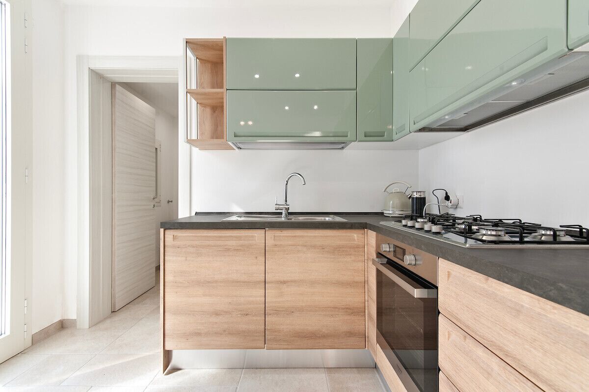 A modern kitchen with wooden cabinets, a gas stove, and a sink.