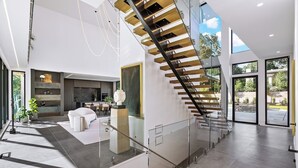 Een modern interieur met een trap, een keukenhoek en een zithoek.