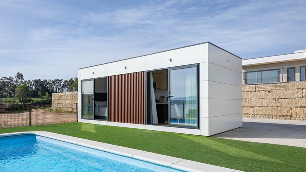 Ein modernes Haus mit Swimmingpool, großen Fenstern und einer Steinsäule.