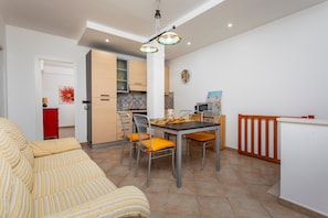 Eine moderne Küche mit Essbereich, einer Couch und einem roten Schrank.