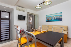 Ein Essbereich mit Tisch, Stühlen und einem Gemälde an der Wand.
