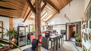 A spacious kitchen with modern appliances, a bar area, and a dining space with chairs.