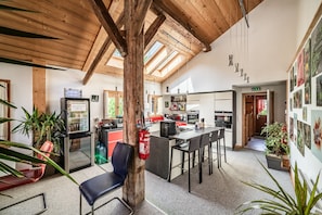 A spacious kitchen with modern appliances, a bar area, and a dining space with chairs. - Room 'Elisthur Chambre N°3' with Mountain View, Private Terrace and Wi-Fi (ST JEAN D'AULPS)