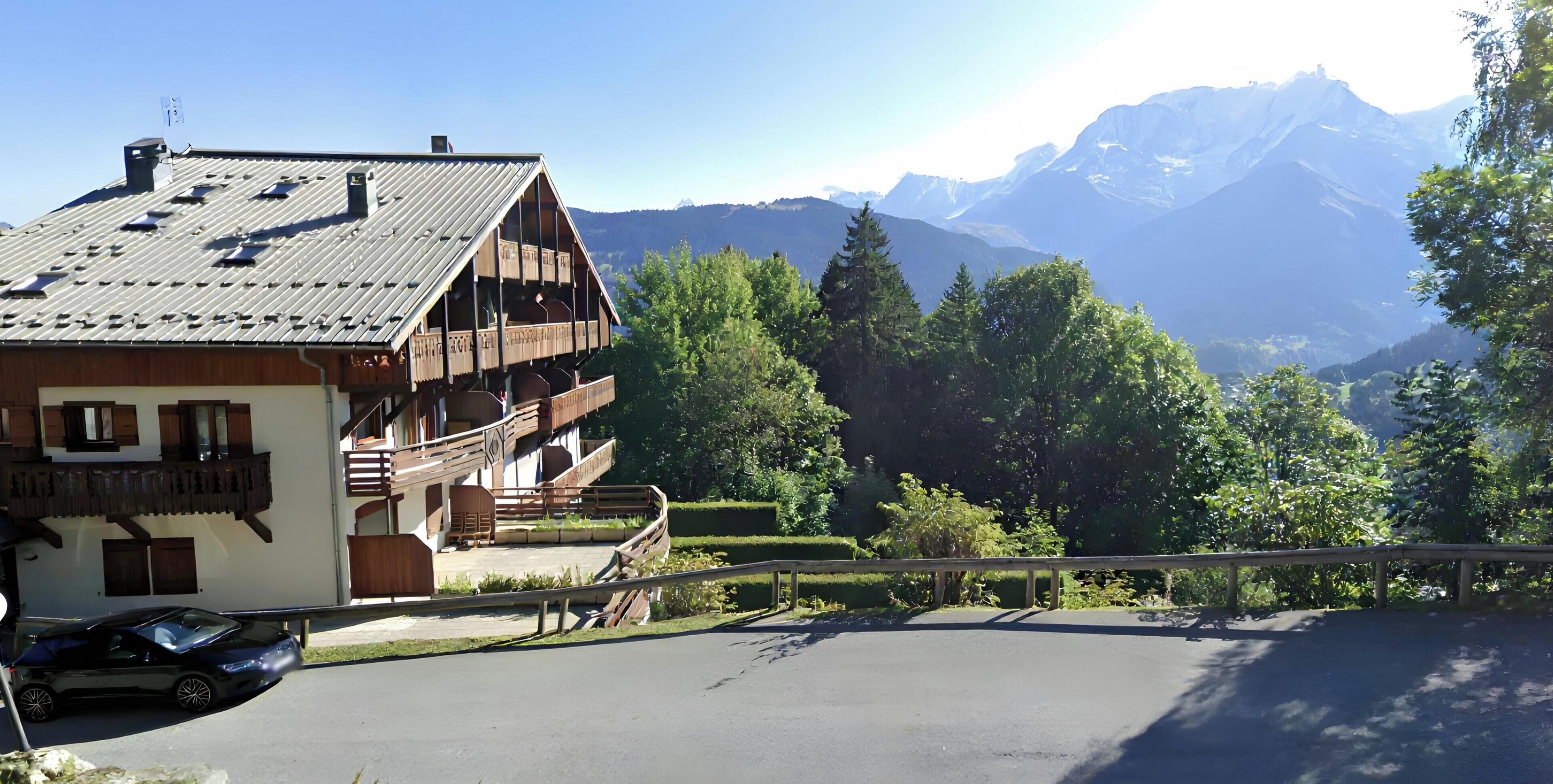 Ein Chalet mit geneigtem Dach, Holzbalkonen und Bergblick.