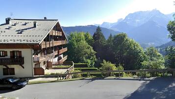 Ein Chalet mit geneigtem Dach, Holzbalkonen und Bergblick.