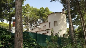 A building with a white exterior, a red-tiled roof, and a satellite dish. - Villa "El Castillito" with Pool, Terrace & Wi-Fi (Playa de Pals)