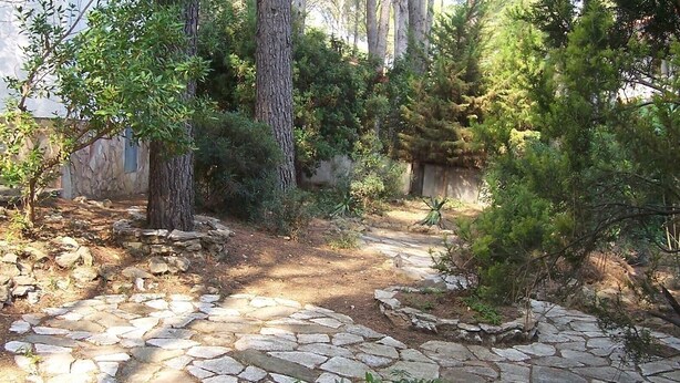 A stone pathway leading through a wooded area with trees and shrubs. - Villa "El Castillito" with Pool, Terrace & Wi-Fi (Playa de Pals)