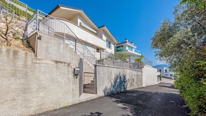 A modern building with a concrete facade, a staircase leading to an upper level, and a clear sky. - Villa 'Renè' with Private Terrace, Wi-Fi and Air Conditioning (Tenno)