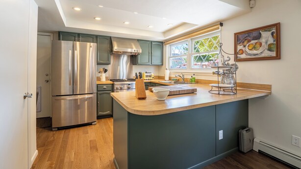 A modern kitchen with a central island, stainless steel appliances, and a window providing natural light.
