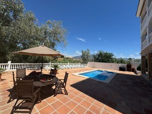 A patio with a pool, outdoor furniture, and a view of the mountains.