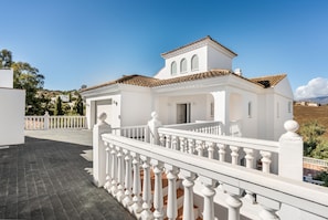 A white building with a tiled roof and a white balcony railing. - Villa Milano with Private Pool, Mountain Views & 4 En-Suite Bedrooms (Las Lagunas de Mijas)