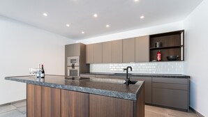 Una cocina moderna con una isla central, electrodomésticos integrados y un diseño minimalista.