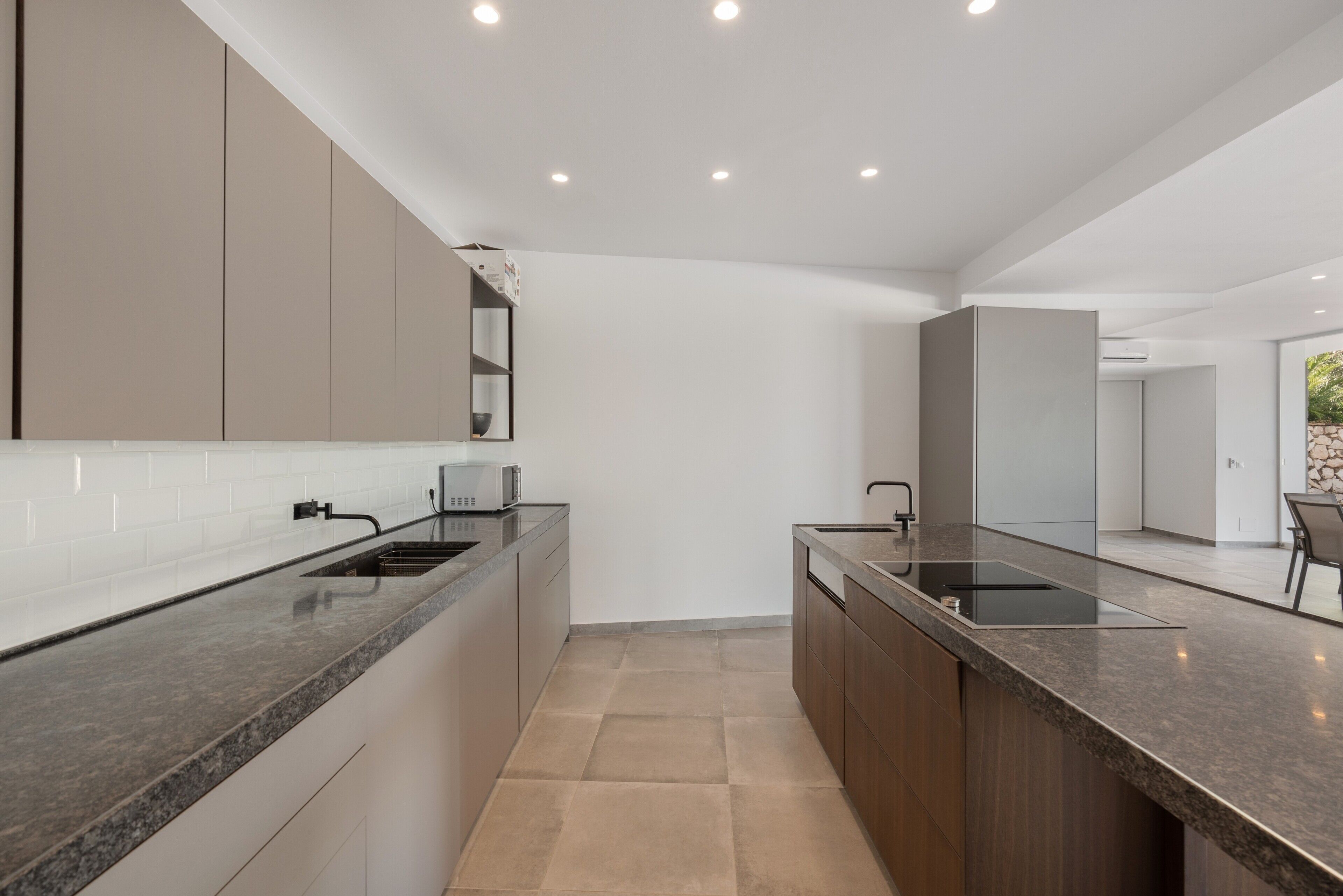 Een moderne keuken met een centraal eiland, inbouwapparatuur en een minimalistisch design.