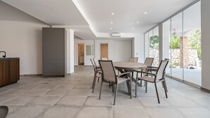 Una cocina moderna con comedor, ventanas amplias y vistas al exterior.