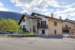 Un bâtiment à deux étages doté d’un balcon, d’une enseigne indiquant qu’il s’agit d’un restaurant, et avec une montagne en arrière-plan.