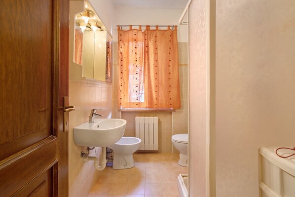 A bathroom with a sink, toilet, and shower curtain.
