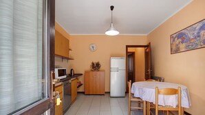Una cocina compacta con refrigerador, microondas y armarios de madera.