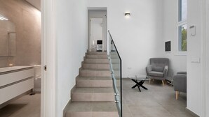 Eine Treppe führt zu einem Schlafzimmer mit einem Bett, einem Sessel und einem Tisch.