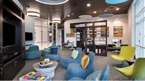 A modern lounge area with comfortable seating, a television, and a bookshelf with magazines. - Charming 2-bedroom beachfront resort near water parks and golf (Myrtle Beach)
