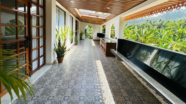 A corridor with patterned tiles, wooden ceiling, and large windows with glass doors. - Roys Villa Havelock Sky 1 (AN)