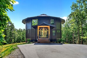 A two-story house with a symmetrical facade, large windows, and a central entrance with steps. - Raven House | Pet-Friendly, Hot Tub & Home Gym! (Black Mountain)