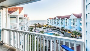 Un hotel frente al mar con varios balcones, una piscina y vistas al océano.