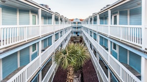 Hotel de varios niveles con un atrio central, que cuenta con balcones y una escalera central.