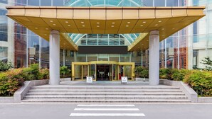 A modern building with a glass facade, a yellow entrance canopy, and a set of steps leading to the entrance. - wanxibinguan (Anqing)