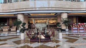 A spacious lobby with a reception desk, seating area, and a large decorative sculpture. - wanxibinguan (Anqing)