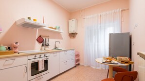 Une cuisine compacte équipée d’une cuisinière, d’un four et d’une petite table à manger avec des chaises.