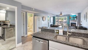 A modern kitchen with granite countertops, stainless steel appliances, and a view to the dining area. - Lakeview Condo w/ 2 Pools & Beach - Family Fun Awaits at 21MM (Osage Beach)