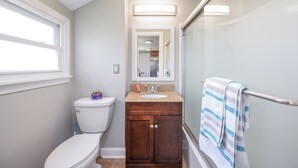 A bathroom with a toilet, sink, and shower.