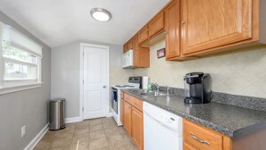 A kitchen with wooden cabinets, a microwave, a coffee maker, and a dishwasher.