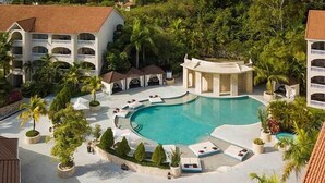 A resort with a large swimming pool, multiple guest buildings, and lush greenery. - Presidential Suites by Lifestyles  (Puerto Plata)