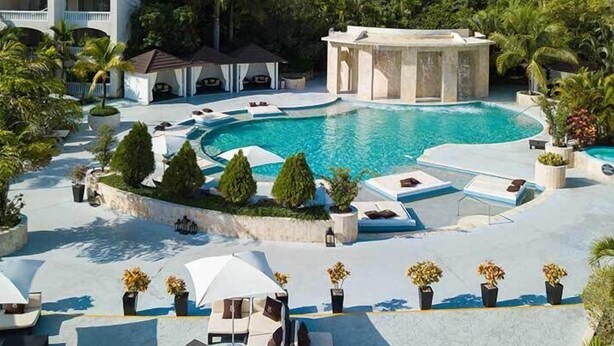 A resort pool area with multiple pools, lounge chairs, and umbrellas. - Presidential Suites by Lifestyles  (Puerto Plata)