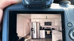 A car dashboard with a rearview camera displaying a kitchen interior. - Coastal Comfort in Marathon FL2BR Poolside Retreat (Marathon)