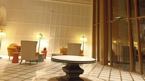 A lobby with a large chandelier, a round table, and seating arrangements. - Hillside Apartment In Sunset Town (Phu Quoc)