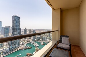 A balcony with a view of a marina and high-rise buildings.