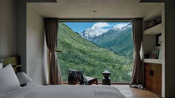 Une chambre dotée d’une grande fenêtre donnant sur les montagnes.