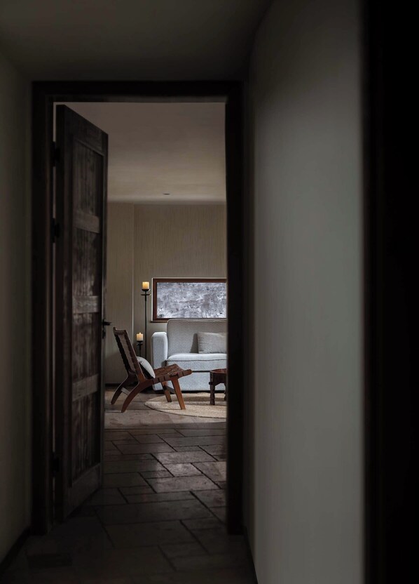 A hallway leading to a room with a sofa, a chair, and a table. - DAINN Mt Siguniang (Ngawa Autonomous Prefecture)