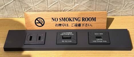 Señal de prohibido fumar y un adaptador con puertos USB.