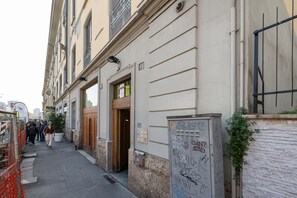 Eine enge Straße mit einem Gebäude, das eine Holztür und einen Briefkasten mit Graffiti zeigt.