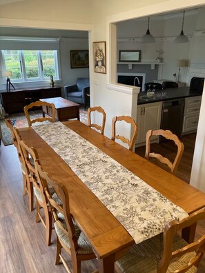Enjoy meals in this dining area with a long table, comfortable seating, and a TV for entertainment.