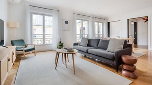 A modern living room with a sofa, a coffee table, a chair, and a television.