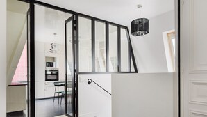 A modern interior with a glass door leading to a kitchen area.