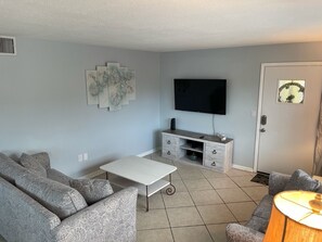 A living room with a sofa, a coffee table, a TV, and a cabinet.