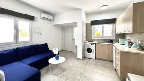 Un apartamento moderno con sala de estar, cocina y lavandería.